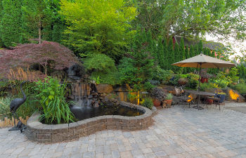 a landscaped garden with patio and water features