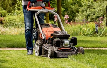 A landscaper mowing a lawn